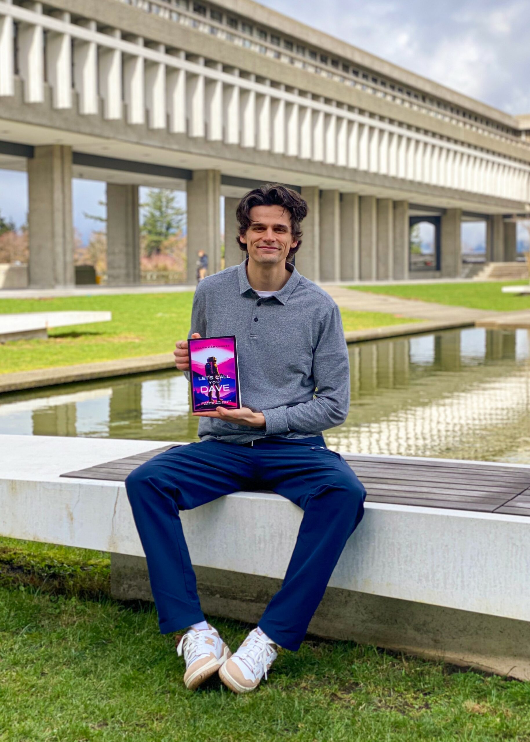 SFU hockey player and author Caleb Parkhouse posing with his new novel