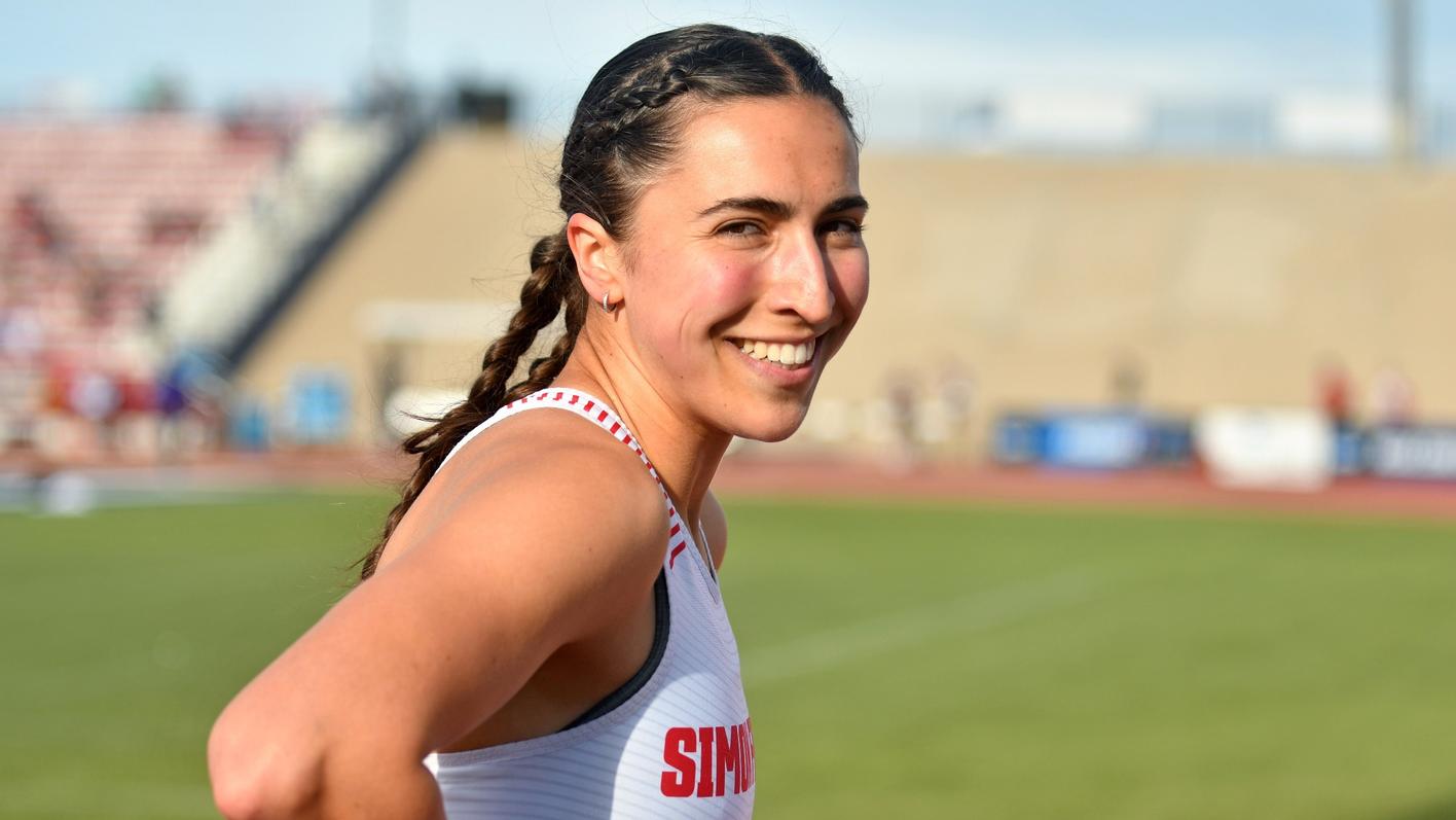SFU track runner Marie Éloïse Leclair smiling at the camera on track