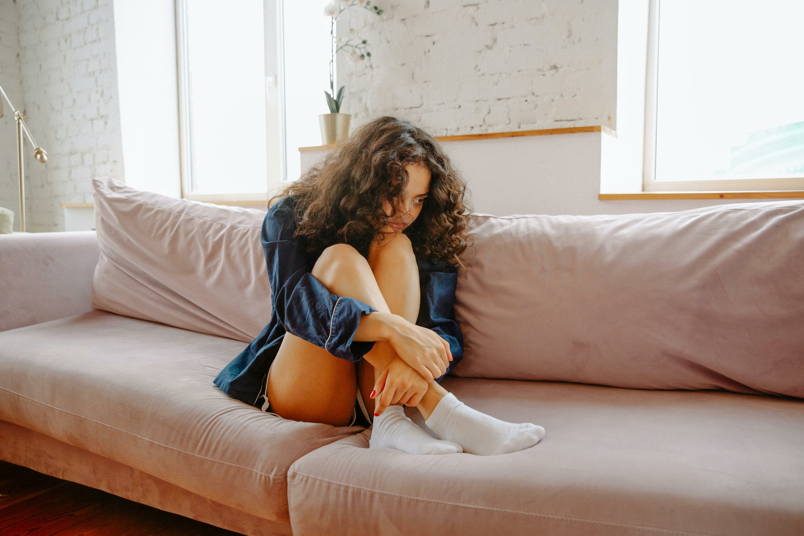 A woman crouched on a couch