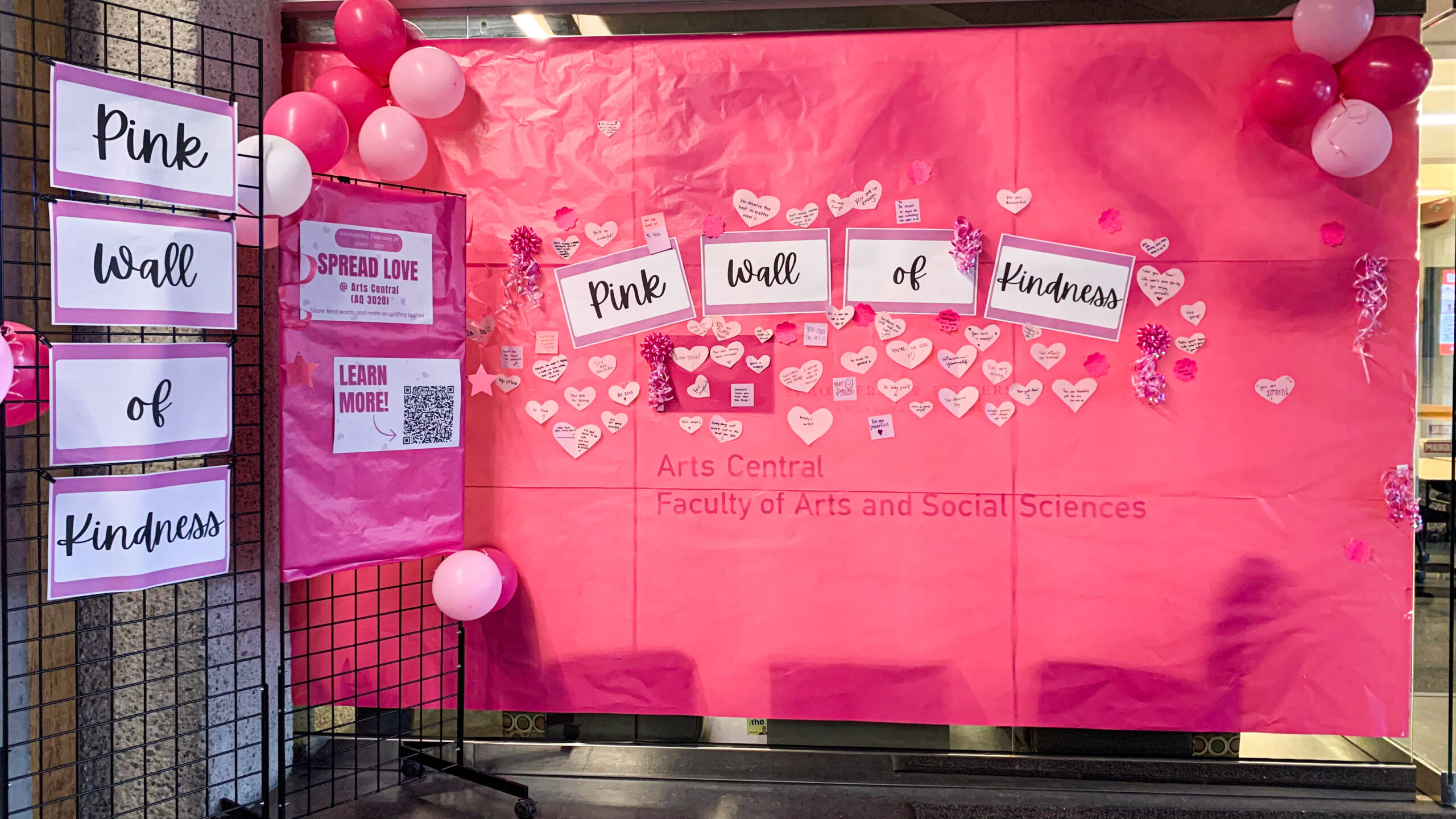 This is a photo of the SFU Pink Wall of Kindess — an event where students put pink post it notes on a large pink wall to share kind messages