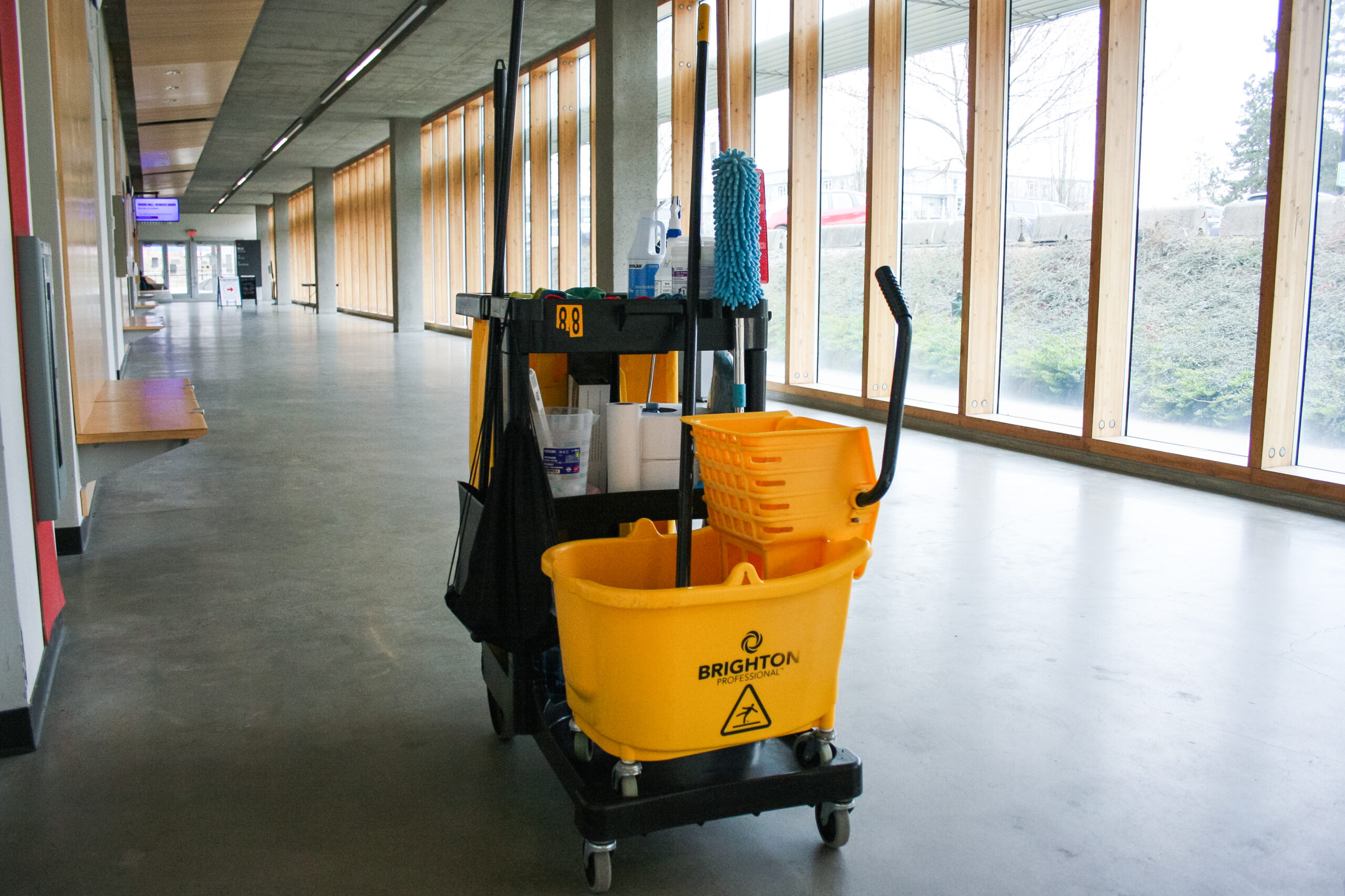 A rolling mop bucket with cleaning gear in a hallway of Blusson Hall