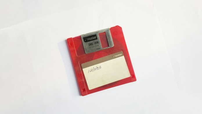 a red floppy disk with a white label near the middle