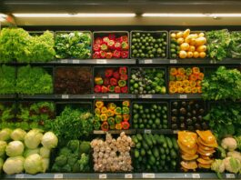 A shelf in a grocery store full of produce