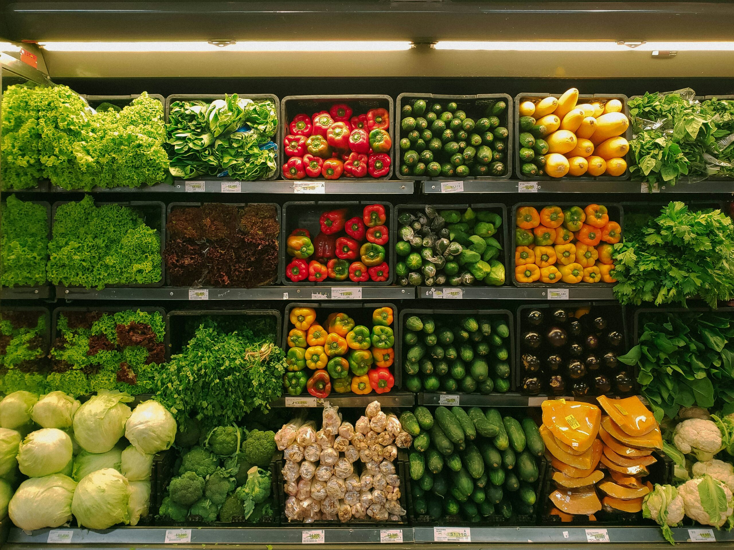 A shelf in a grocery store full of produce