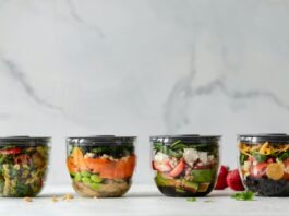 Four clear plastic bowls with vegetables inside