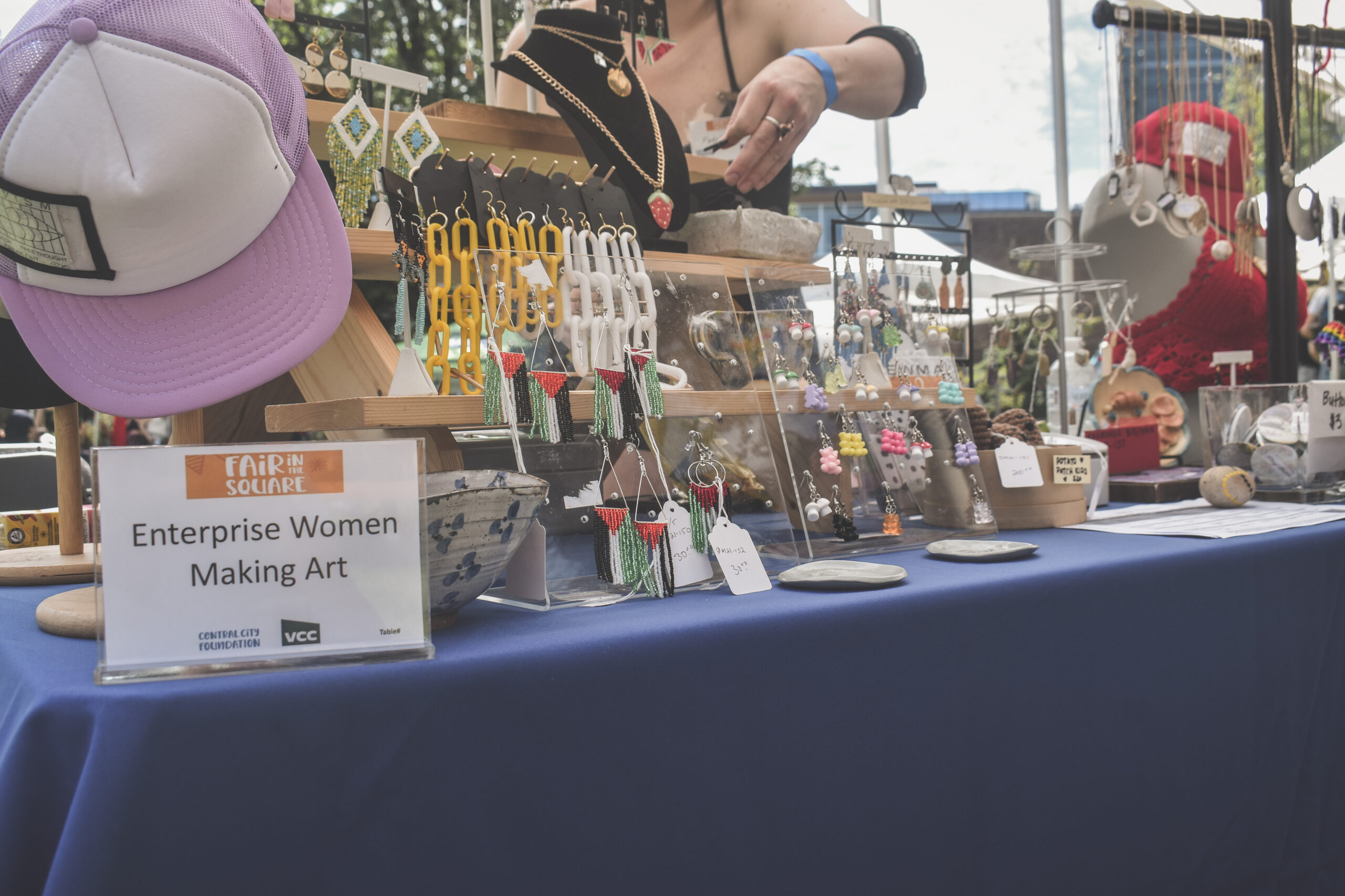 Delicate jewellery pieces are on display at a retail stall, including earrings of the Palestinian flag made with small beads.