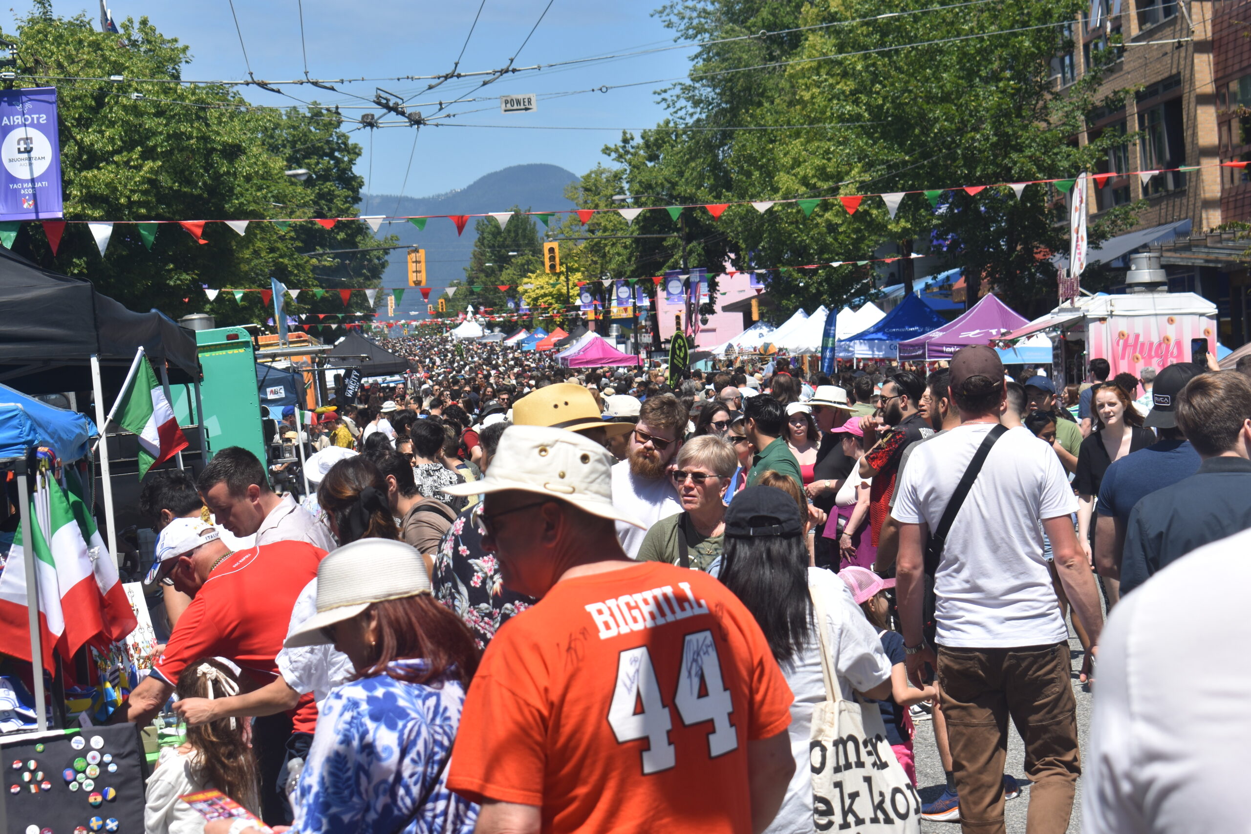 A crowded block of people with red, green, and white banners over their heads.