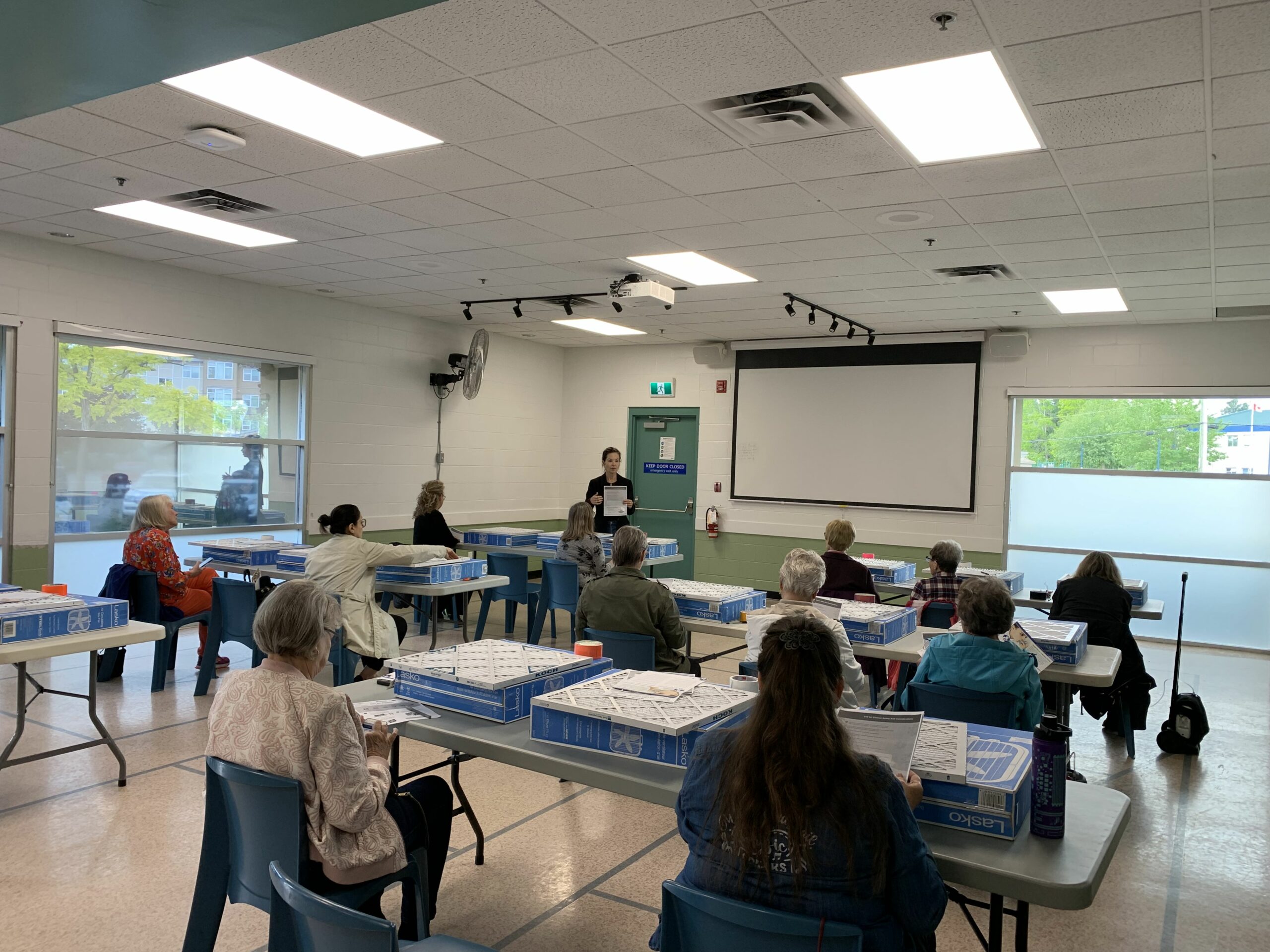 This is a photo of the Pacific Institute on Pathogens, Pandemics and Society holding a workshop to build DIY air filters in a classroom-type setting.