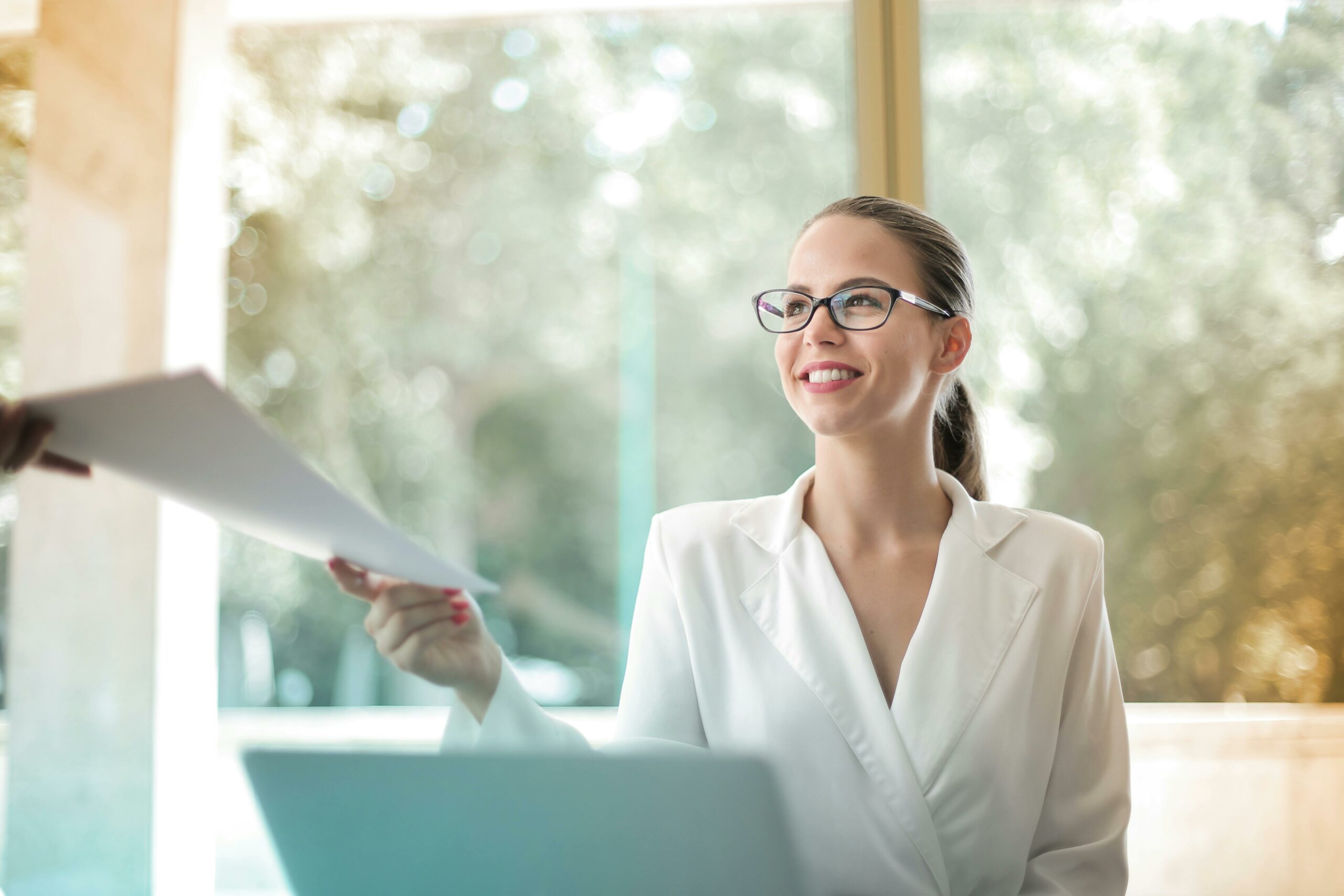 A businesswoman hands over documents to her colleague.