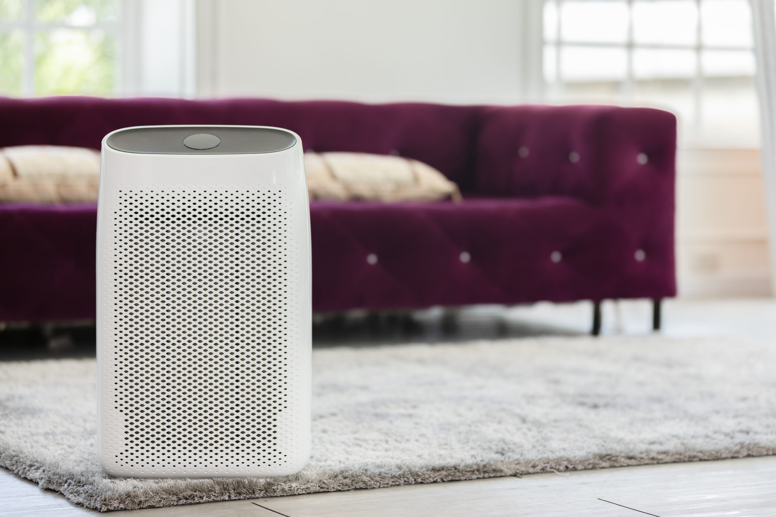 A white air purifier on the floor.