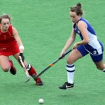 Peakie gets sporty Two women competing for a goal in field hockey.