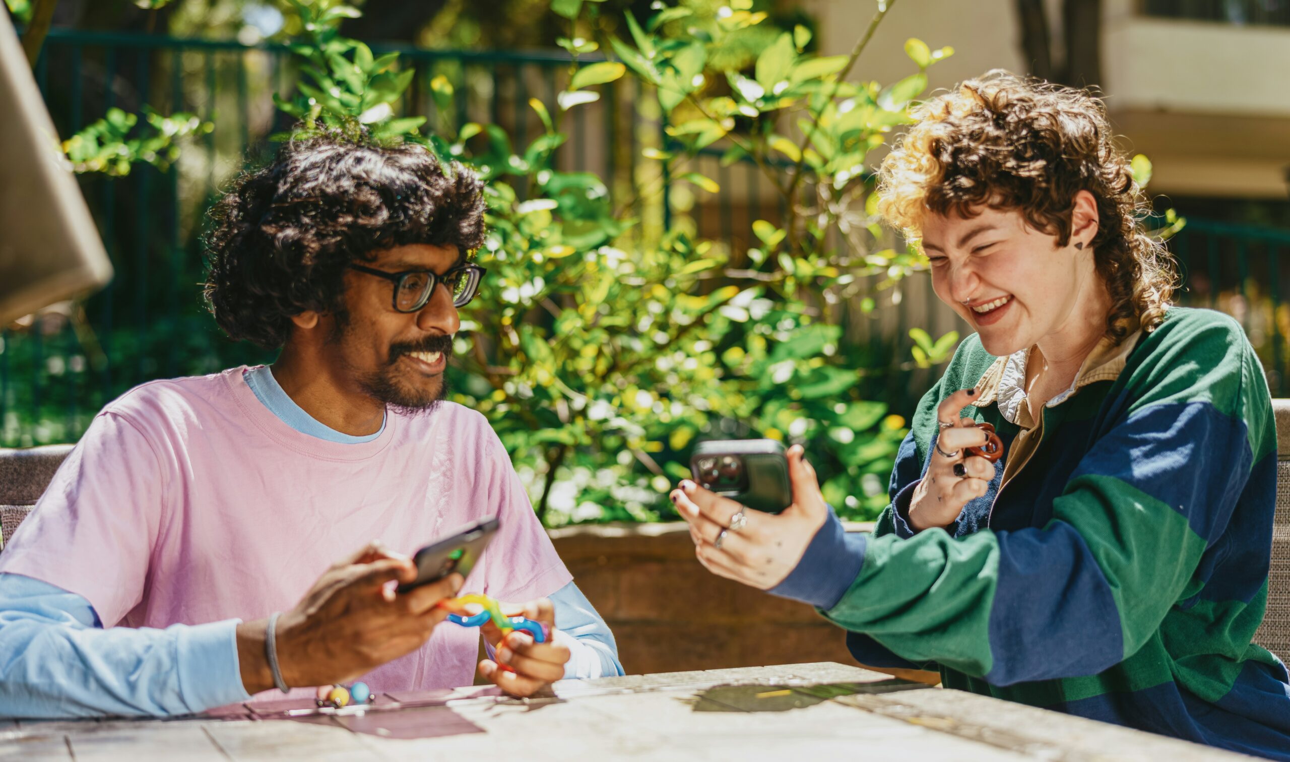 Two people laughing and looking at a phone.