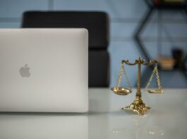 Balanced scales of justice in next to an open laptop