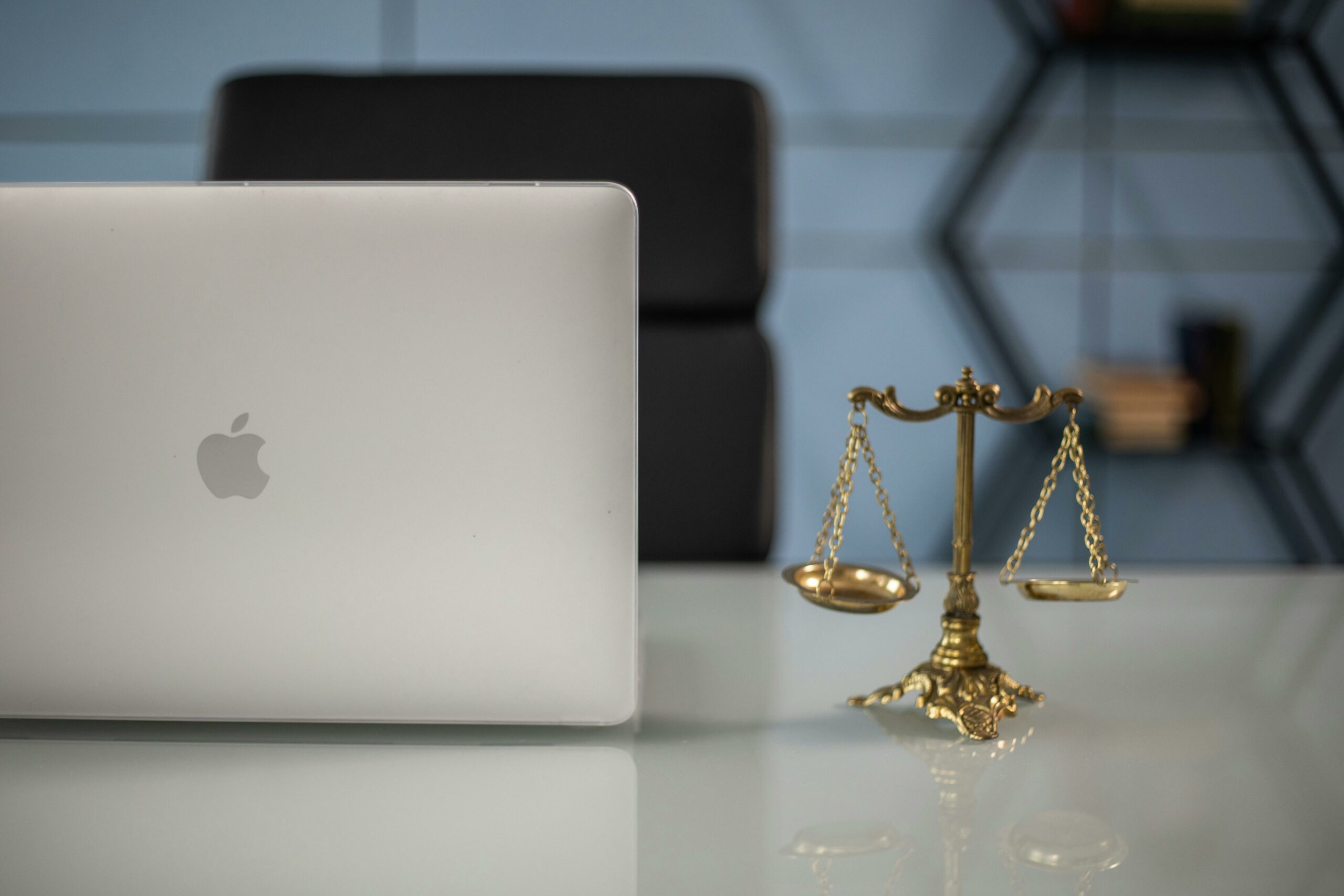 Balanced scales of justice in next to an open laptop