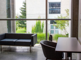 A small black couch and a chair with a desk in a quiet corner at SFU.