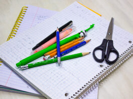 Notebooks with pens and scissors on top