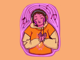 A person with short brown hair and a pair of headphones wears an orange shirt with a wavy, firelike pattern on the front.