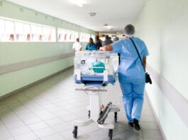 A healthcare worker pushing a cart in a hospital