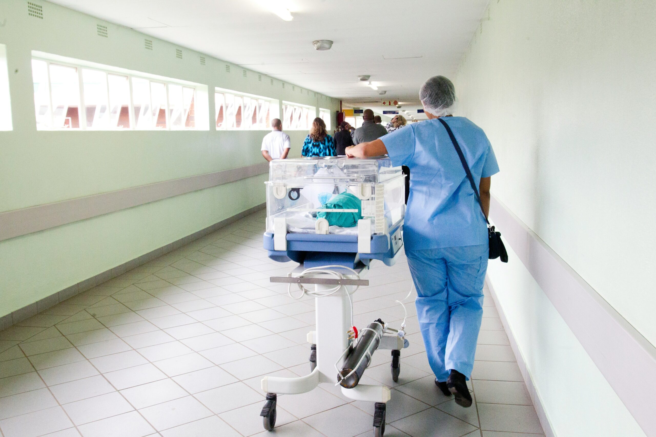 A healthcare worker pushing a cart in a hospital