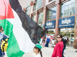 This is a photo of a recent protest against Indigo showing people outside an Indigo bookstore.