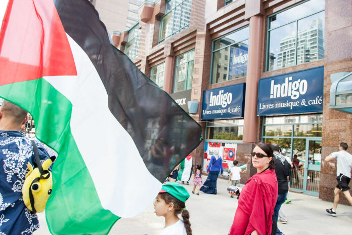 This is a photo of a recent protest against Indigo showing people outside an Indigo bookstore.