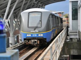 This is the photo of the front of a Skytrain going to King George moving along the tracks.