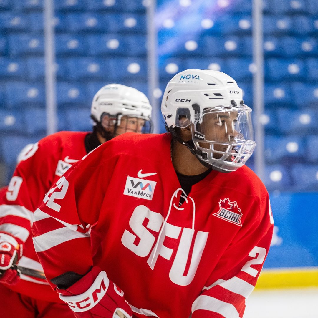 A close-up of a player in a red hockey jersey with the words “SFU” written in white.