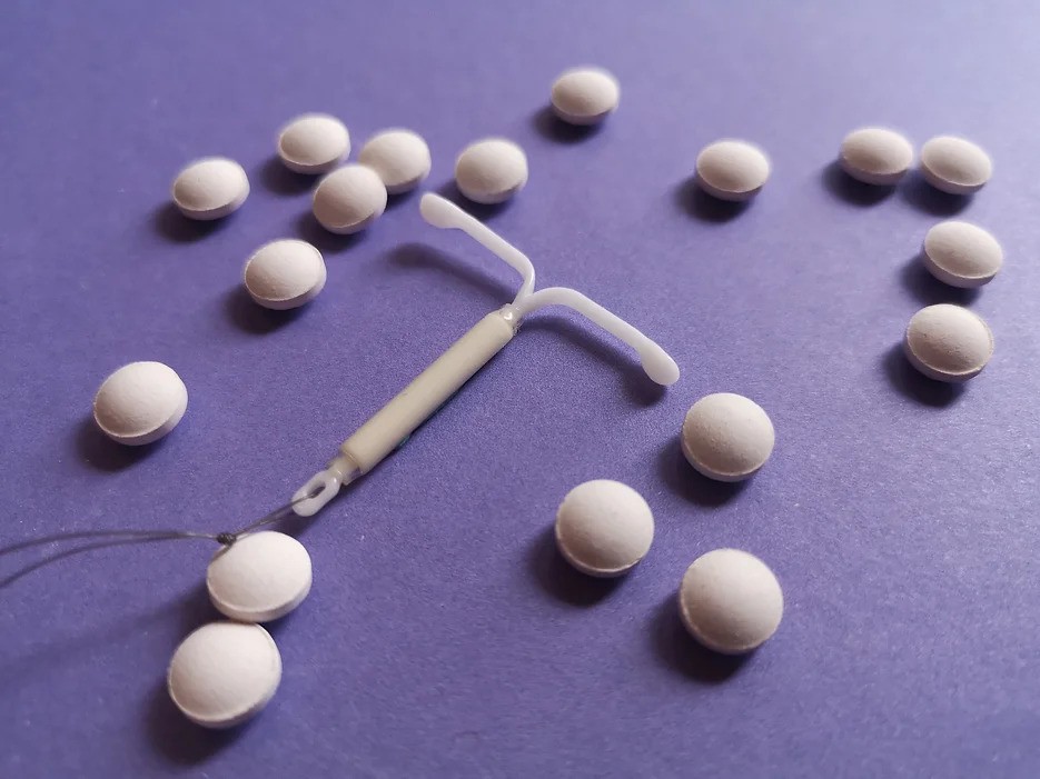 This is a photo of an intrauterine device (IUD) and a type of contraception pill.