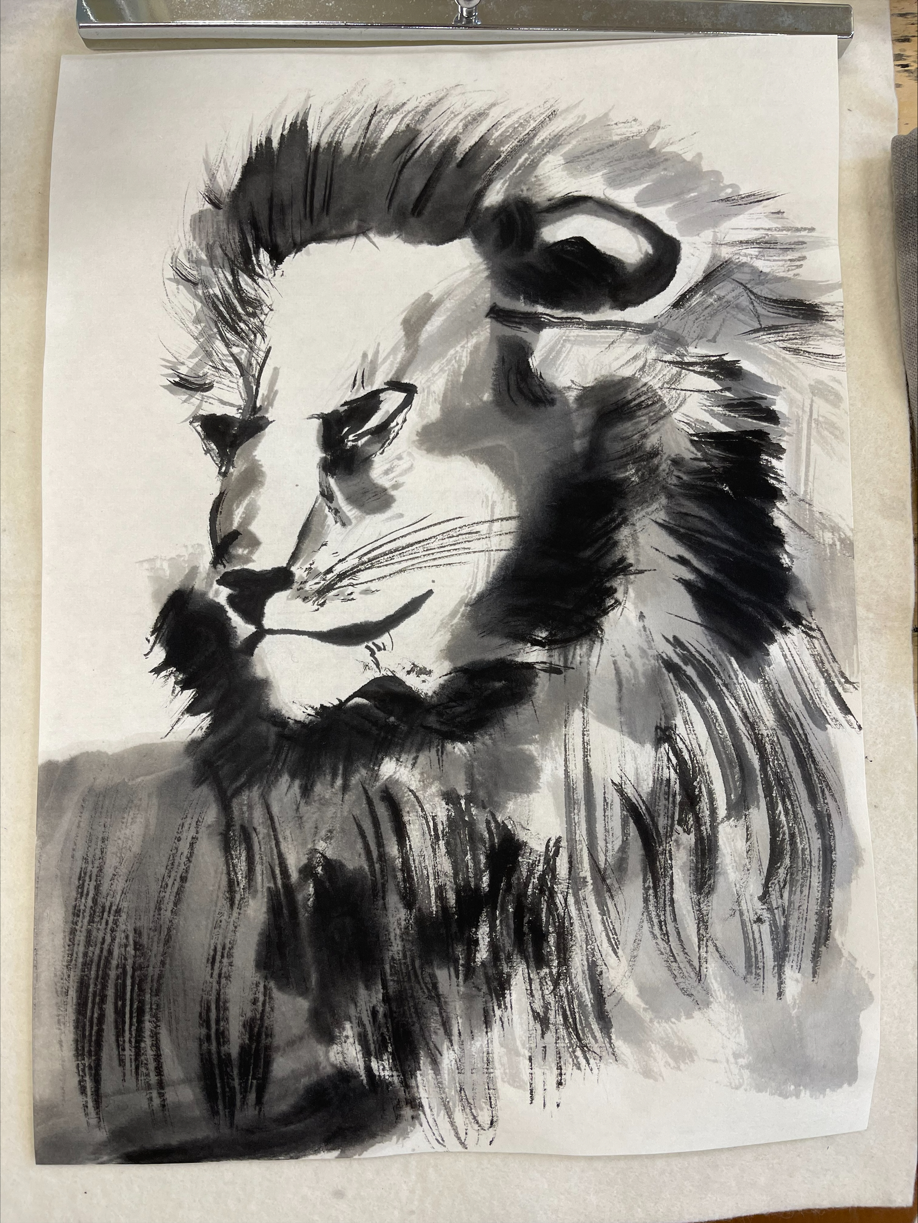 a lion painted in light, watery brushstrokes of varying shades of black and gray.