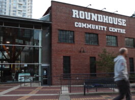 A red brick building with the words “Yaletown roundhouse community centre” on the top. Attached to it is a section made up of glass windows.