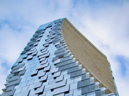 A large winding high rise building as seen from below