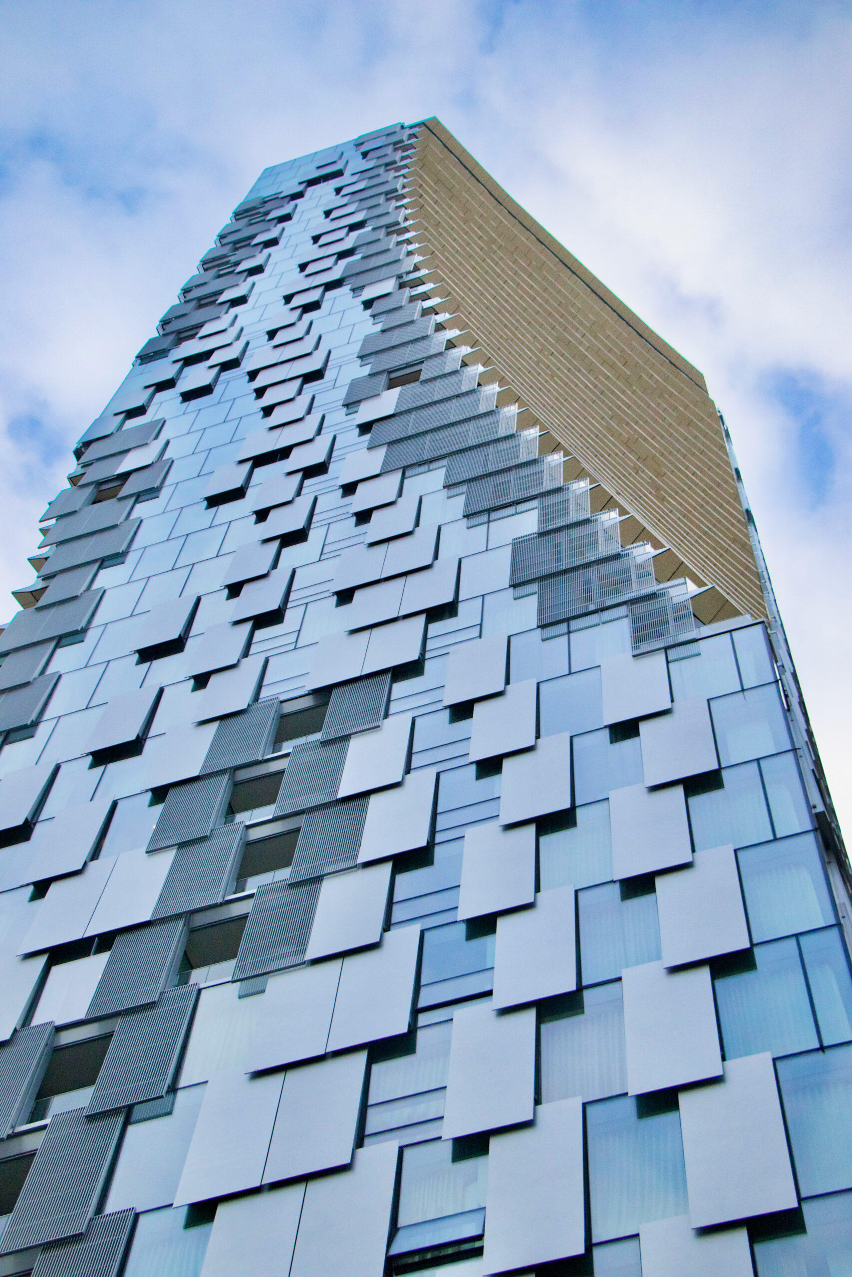 A large winding high rise building as seen from below