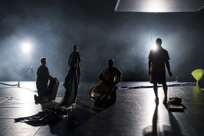 All That Remains NEW - @Christoffer Brekne - Csongor Szabo Four individuals pose with their backs to the camera, their figures illuminated by a light that shines from in front of them.