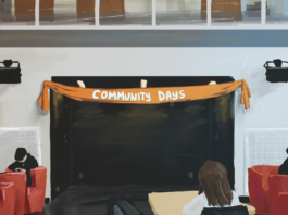 A room in the SUB with red chairs and desks. Strung up along the wall is an orange banner that reads “Community Days.”