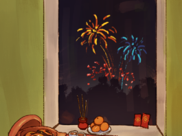 A table with claypot fish and rice, a plate of dumplings, a plate of oranges, incense, and red envelopes. Outside a nearby window, fireworks light up the night sky.