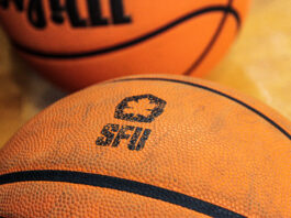 A close-up of an orange basketball with the ‘SFU Red Leafs’ logo at the focal point, stamped in black.