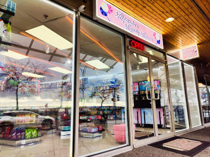 A storefront window showing shelves of colourful candies. A pink sign at the top of the door reads “Ricardo’s Kandy Korner.”