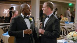 two men dressed up in formals at a party  looking at each other 