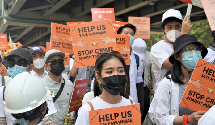 people wearing masks, holding banners while protesting