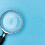 Who killed McFogg? A magnifying glass pressed against a blue background.