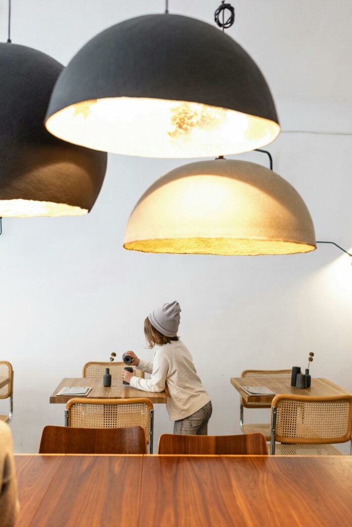 A picture of a restaurant with three bright lights and a child under them.