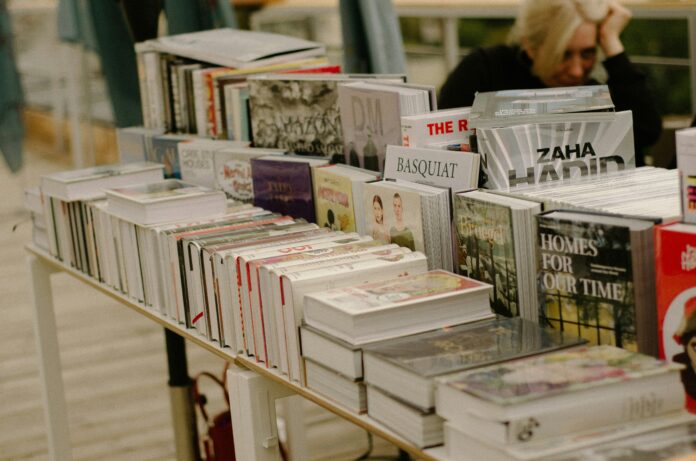 The picture shows a book fair, focused on a few books on and around a table