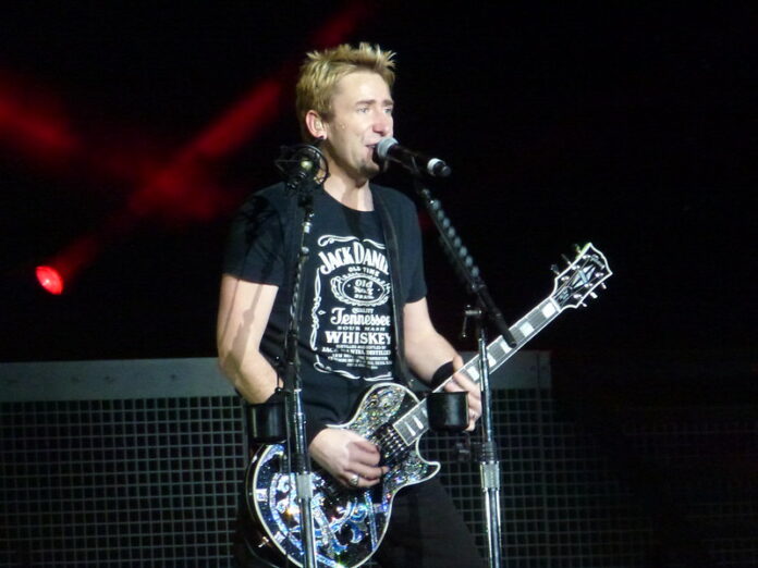nickelback pic web only Chad Kroeger, lead singer of Nickelback, strumming his guitar at a concert.