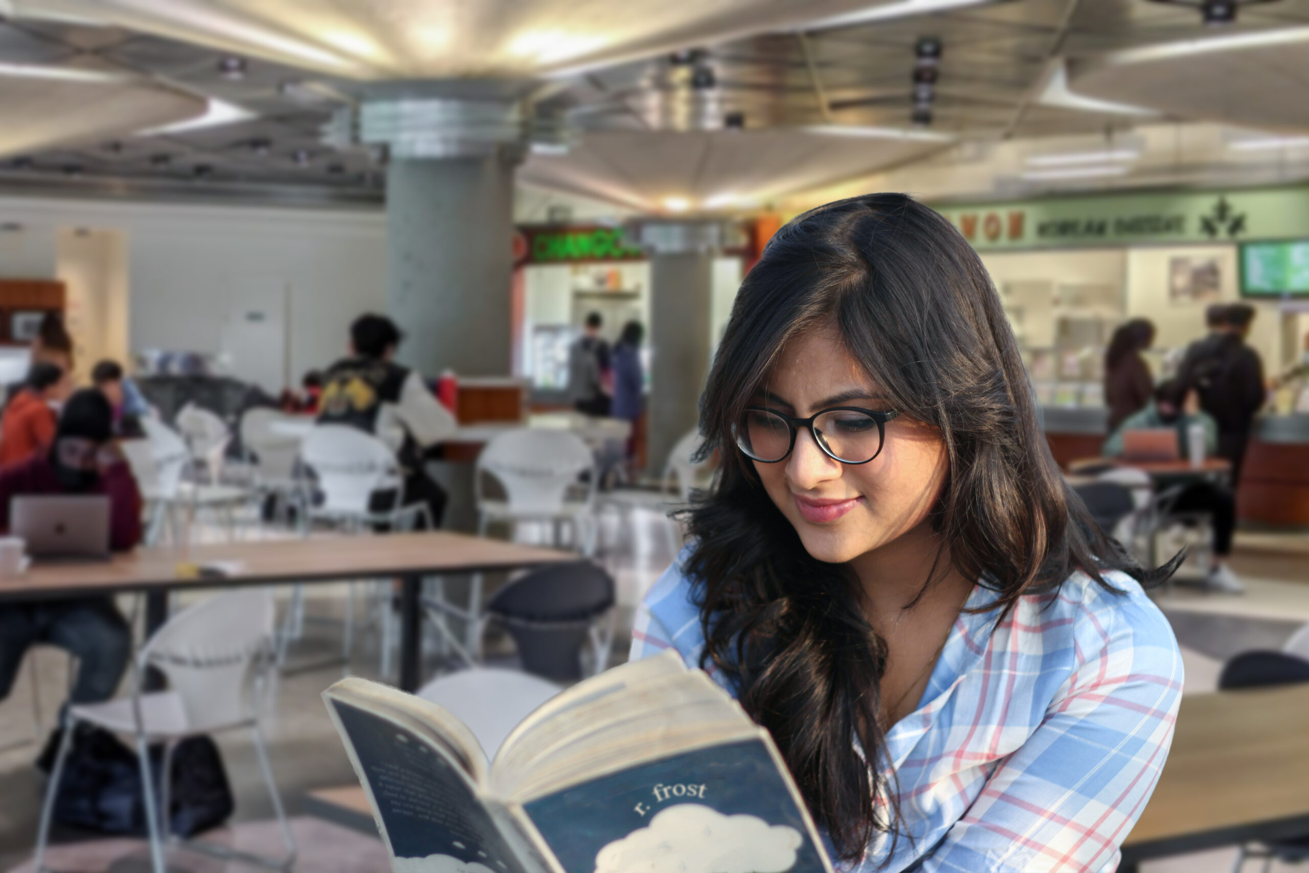 PHOTO (turned into EDIT): of someone sitting in the MBC food court (camera angle facing the restaurants) looking very constipated. In their hands should be a Robert Frost poetry book (should be available by request at the library). In front of the subject should be a prop that makes it look like they've just had some food at the caf.