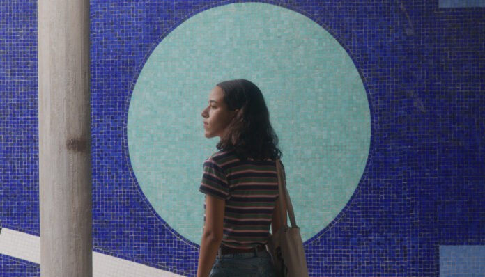 A woman standing in front of a mosaic