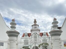 A photo of Tanjila Afrin standing in front of a large white building.
