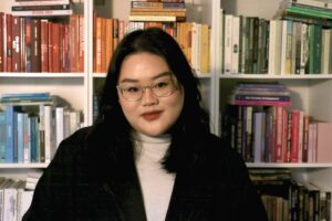 A headshot of Sarah Law behind a bookshelf.