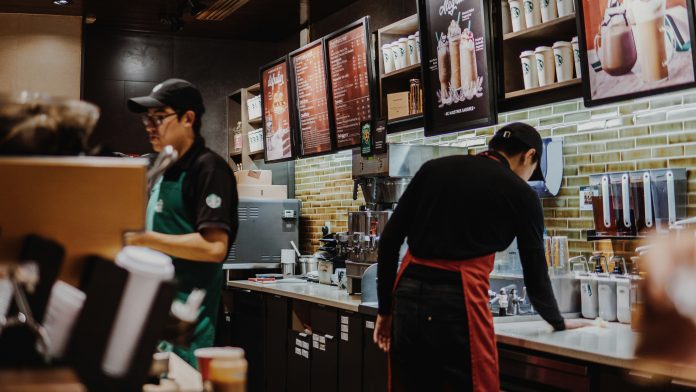 Employees working inside a bustling Starbucks.