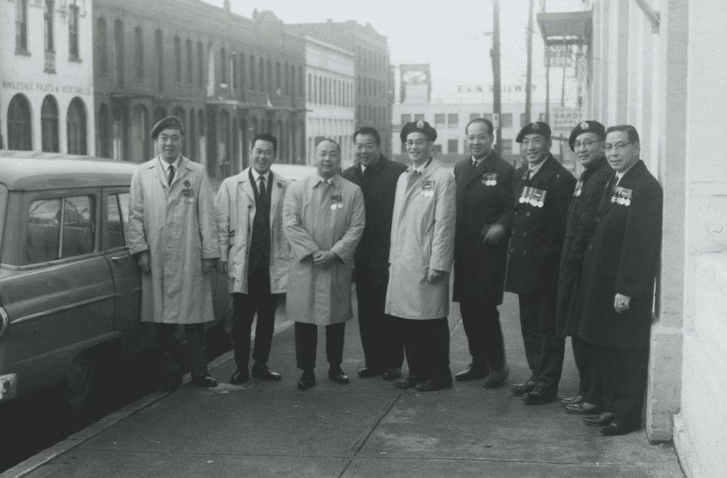 Nine Chinese Canadian veterans stand side-by-side in a black and white photograph from 1981.