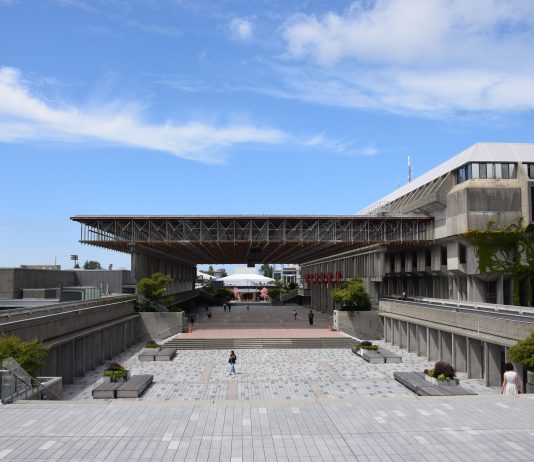 What did UniForum cost SFU? Convocation Mall is pictured on a bright day. A few people are walking around, and the sky is bright blue.